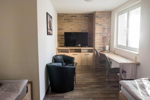 a room with a desk and chairs and a television at Ubytování Stračena in Ostrava