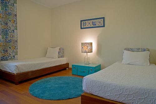 a bedroom with two beds and a blue rug at Hotel A.S. Lisboa in Lisbon
