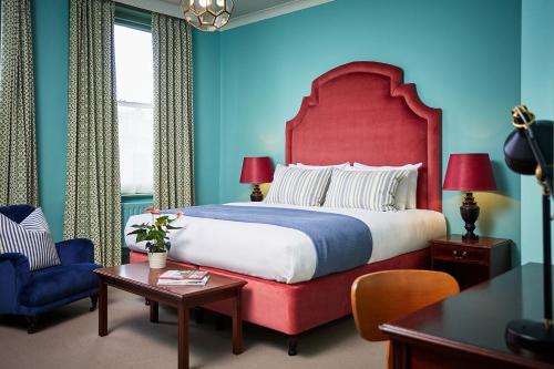 a bedroom with a large bed with a red headboard at The Green Dragon Hotel in Hereford