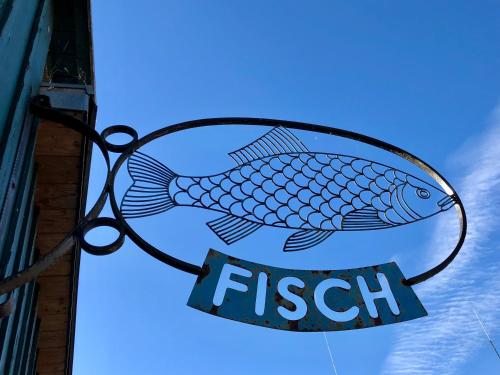 a fish sign hanging outside of a restaurant at PerlePlau in Plau am See