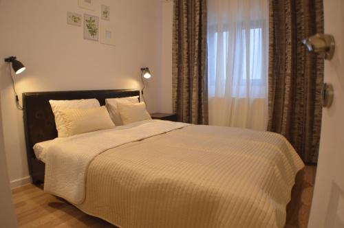 Un dormitorio con una cama y una ventana con cortinas. en Central GREEN HOUSE, en Bucarest
