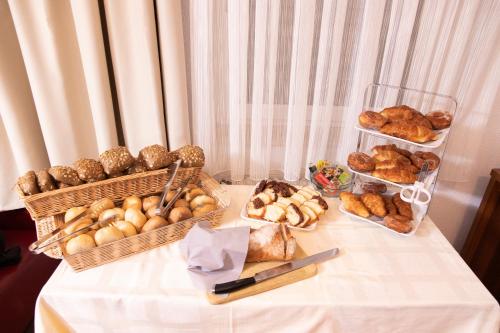 a table with baskets of bread and pastries on it at ZUM ZIEL Hotel Grenzach-Wyhlen bei Basel in Grenzach-Wyhlen