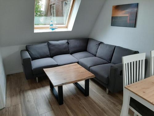 ein Wohnzimmer mit einem blauen Sofa und einem Holztisch in der Unterkunft Steuerbord in Wangerland