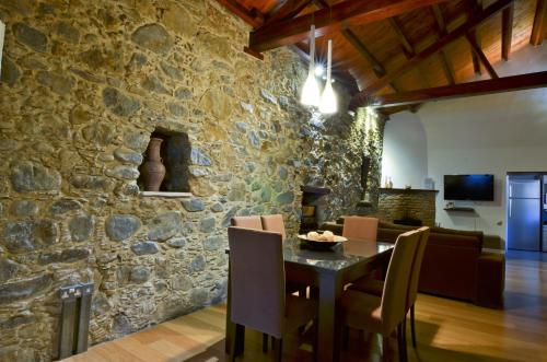 a kitchen and dining room with a stone wall at To Kastri in Kalopanayiotis