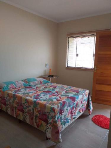 a bedroom with a bed and a window and a table at Pousada Ilha Sul in Cananéia
