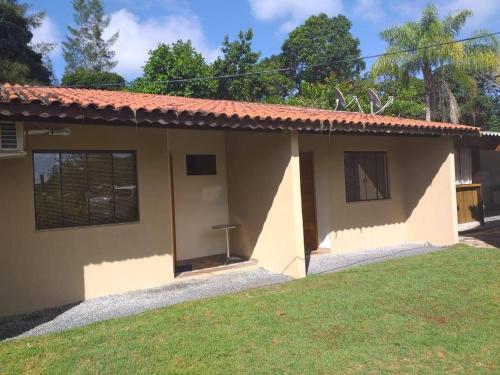 a small house with a green lawn in front of it at Pousada Ilha Sul in Cananéia