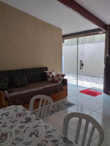 a living room with a couch and a table and chairs at Pousada Ilha Sul in Cananéia