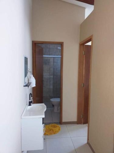 a white bathroom with a sink and a toilet at Pousada Ilha Sul in Cananéia