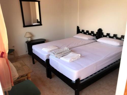 a bedroom with two beds with a mirror and a chair at PLAYA PARAISO in Playa Honda