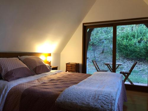 1 dormitorio con cama y ventana grande en Côté Coteau, en Villiers-sur-Loir