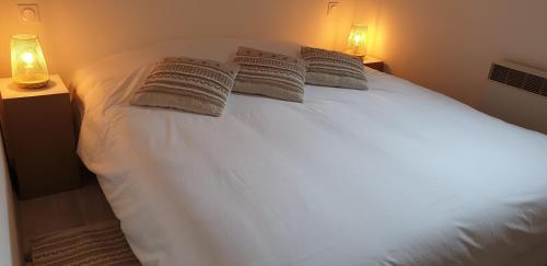 a bedroom with a white bed with two pillows at Opaline Baie de somme in Ault