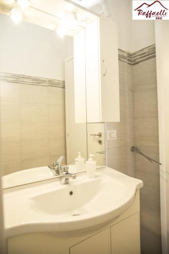 a bathroom with a white sink and a mirror at B & B Raffaello in Terzigno