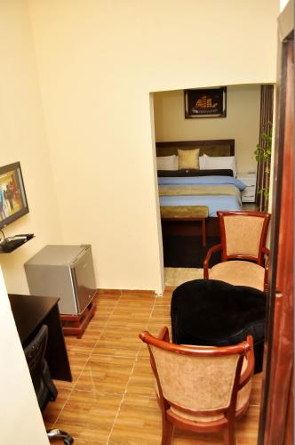 a bedroom with a bed and two chairs and a desk at J Gibson Hotel in Lagos