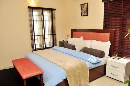 a bedroom with a large bed with a red chair at J Gibson Hotel in Lagos