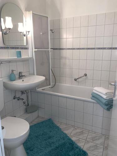 a bathroom with a sink and a tub and a toilet at Mariposa 2 in Bad Harzburg