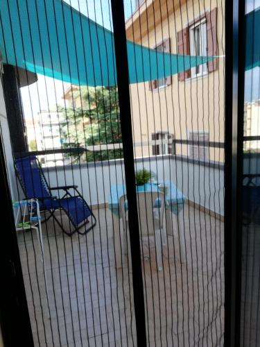 a screened in porch with a chair and a building at Blue Apartment in Pescara