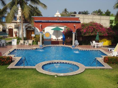 a large swimming pool in the middle of a yard at Hotel Hacienda Flamingos in San Blas