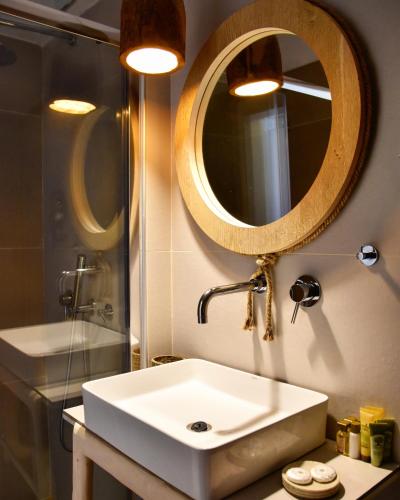 a bathroom with a white sink and a mirror at Angelos Design Suites in Patitiri