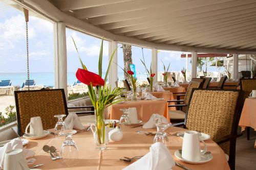 un restaurante con mesa y vistas al océano en The Club Barbados - All Inclusive - Adults Only, en Saint James