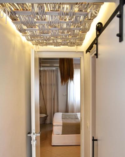 a room with a bed and a ceiling at Angelos Design Suites in Patitiri