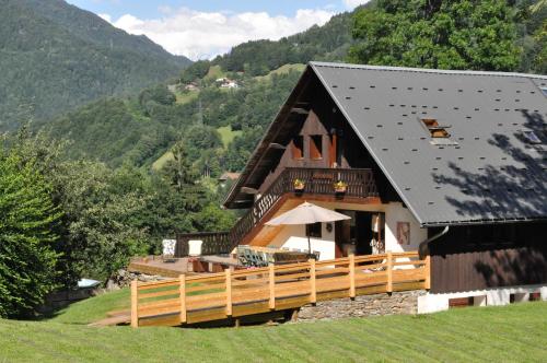 a large building with a black roof and a hill at La Grange Aux Loups in Queige