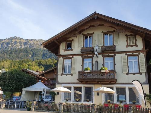 a building with a balcony with umbrellas in front of it at Hotel Rosengärtli in Leissigen