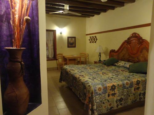 a bedroom with a bed and a table in a room at Hotel Hacienda Flamingos in San Blas