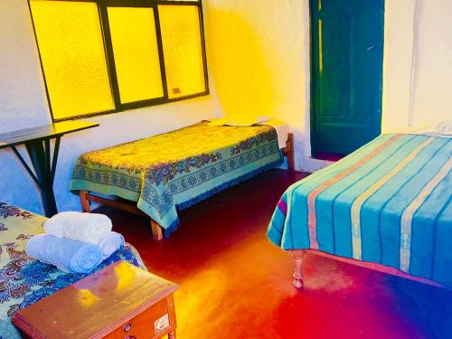 Pokój z dwoma łóżkami i stołem w obiekcie My Friend Surf Hostal w mieście Trujillo