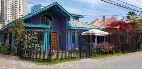 una casa morada y azul con una valla negra en Las Tinajas Frente A La Playa en Coquimbo