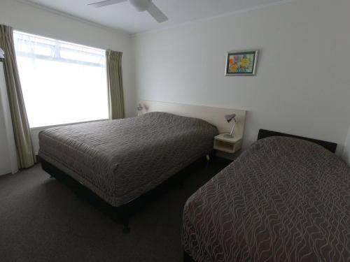 a hotel room with two beds and a window at Castle Court Motel in Wellsford