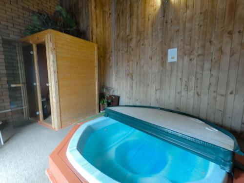 a swimming pool in a room with a wooden wall at Castle Court Motel in Wellsford