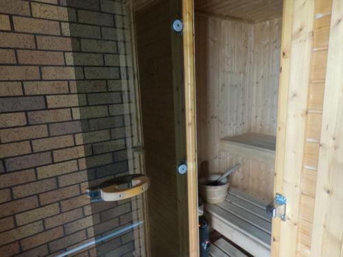 a bathroom with a sink and a brick wall at Castle Court Motel in Wellsford