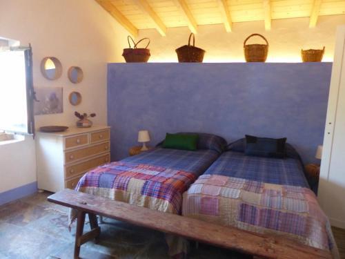 um quarto com uma cama e um banco de madeira em Herdade da Carapuça em Portalegre