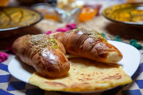 Riad Naya في مراكش: اثنين من النقانق والخبز على طبق على طاولة