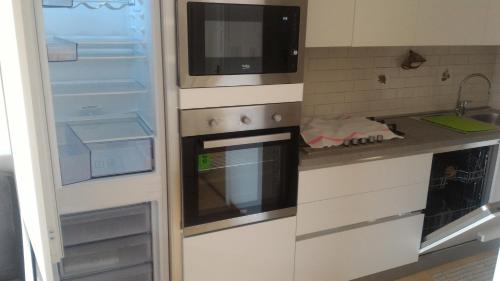 a kitchen with an open refrigerator and a stove at ANESI appartamenti in Baselga di Pinè