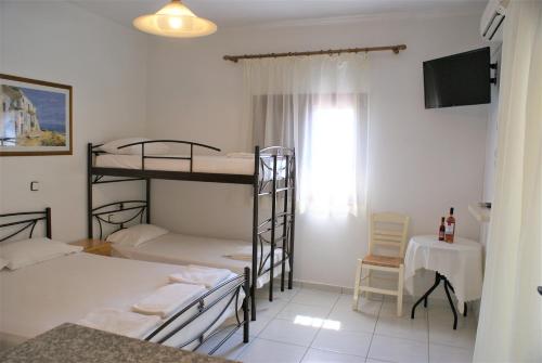 a room with two bunk beds and a television at Grammatoula in Nikiana