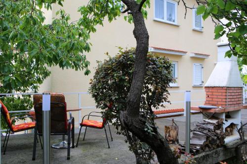 a patio with chairs and a tree and a dog at Apartment Rosa in Rijeka