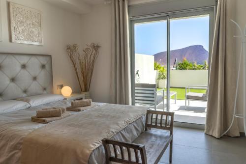 a bedroom with a large bed and a large window at TEJITA BEACH APARTMENT in El Médano