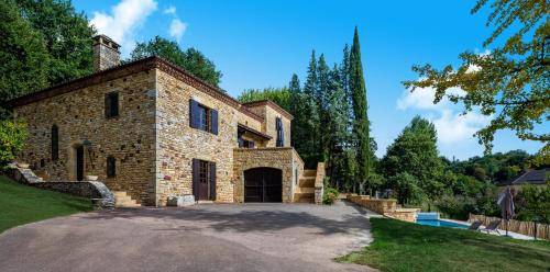 une grande maison en pierre avec une allée. dans l'établissement La Trappezienne, à Sarlat-la-Canéda