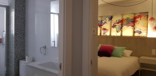 a bedroom with a bed and a bath tub next to a bathroom at La Parada de Echegaray in Zaragoza