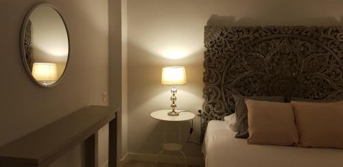 a bedroom with a bed with a mirror and a lamp at La Parada de Echegaray in Zaragoza