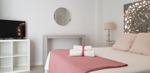 a white bedroom with a bed with towels on it at La Parada de Echegaray in Zaragoza