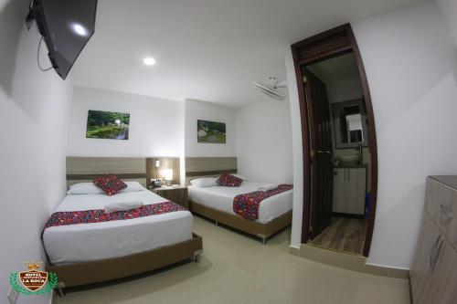 a hotel room with two beds and a mirror at Hotel La Roca San Rafael in San Rafael