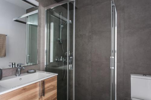 a bathroom with a shower and a sink at Homz Studios Faliro in Athens