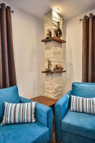 two blue chairs and a table in a living room at Giardino Lux Apartments in Ulcinj