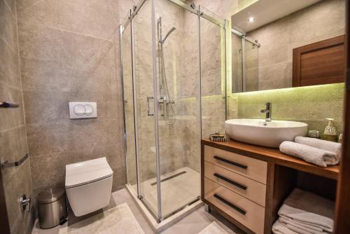 a bathroom with a glass shower and a sink at Giardino Lux Apartments in Ulcinj