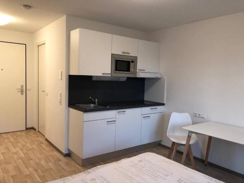 una pequeña cocina con fregadero y microondas en 1-Zi. Apartment, Echterdingen bei Flughafen/Messe Stgt., en Leinfelden-Echterdingen