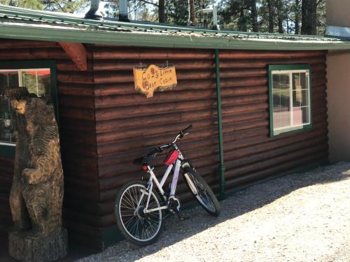 a bike parked next to a cabin with a bear at Gonzales Cozy Little Bear Cabin in Ruidoso