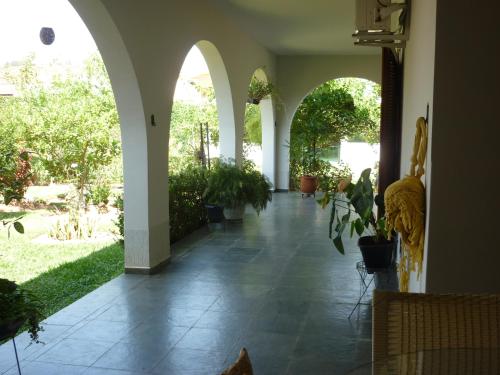 a hallway with arches and potted plants in a house at Pousada Santa Fé in Aparecida