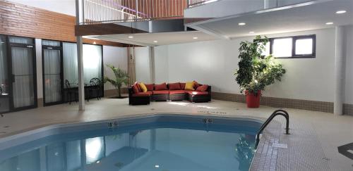 a swimming pool in a building with a couch at Super 8 by Wyndham Spruce Grove in Spruce Grove